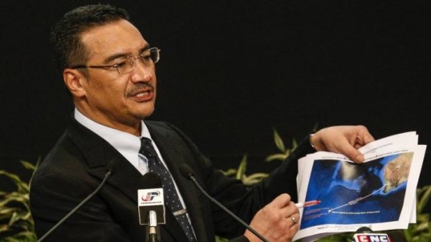 Malaysia's acting Transport Minister Hishammuddin Hussein holds satellite images as he speaks about the search for the missing Malaysia Airlines Flight MH370 in Kuala Lumpur.