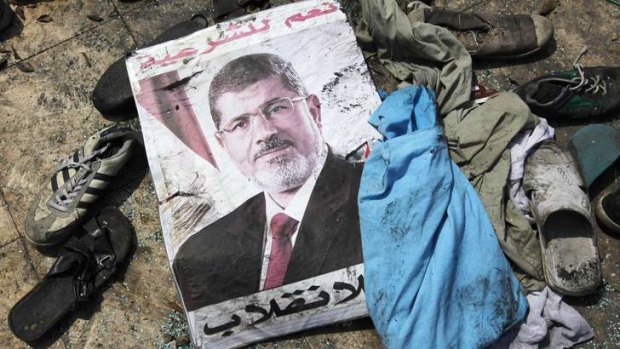 A poster of deposed Egyptian President Mohamed Mursi that reads "No to the coup" lies amid the debris of a cleared protest camp outside the burnt Rabaa Adawiya mosque in Cairo.