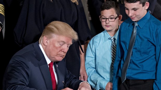 US President Donald Trump signs a presidential memorandum after delivering remarks on combating drug demand and the opioid crisis in the East Room of the White House in Washington, DC.