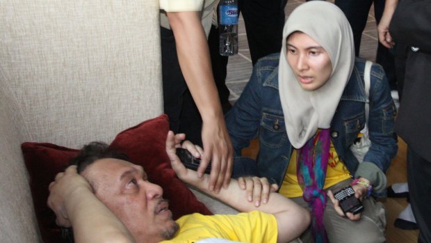 Malaysian opposition leader Anwar Ibrahim, left, is comforted by his daughter Nurul Izzah after he fell following a tear gas attack by police during a mass rally for electoral reform in Kuala Lumpur in 2011.