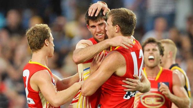 Josh Hall celebrates with Gold Coast Suns team mates after kicking a goal during their match against Richmond at Cazaly's Stadium in Cairns.