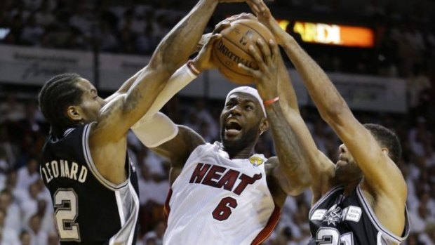 LeBron James tries to get past Kawhi Leonard and Tim Duncan during game three of the NBA Finals.