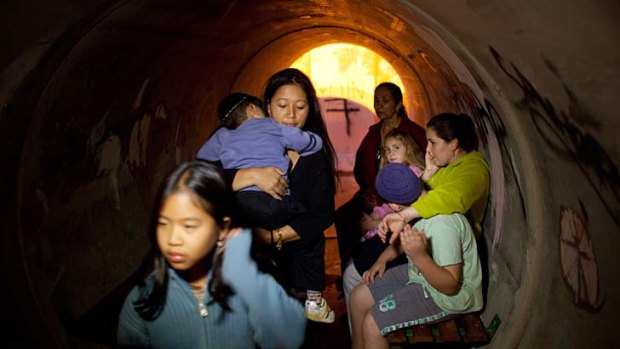 Sheltering for safety &#8230; Israelis in the town of Nitzan take refuge in a large concrete pipe used as a bomb shelter after a rocket was launched from the Gaza Strip on Thursday.