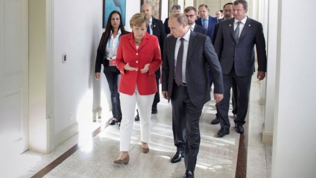 German Chancellor Angela Merkel talks to Russian President Vladimir Putin in Rio de Janeiro.