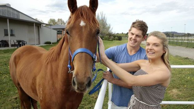 NSW batsman Daniel Hughes with his partner Erin Molan at Nick Olive's stables at Thoroughbred Park where their two-year-old filly is being trained.