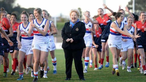 Move over, boys: Western Bulldogs president-for-a-day Susan Alberti with the two women's teams that will contest a curtain-raiser at the MCG on Saturday night.
