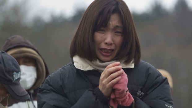 Suffering nation ... a mourner at a mass funeral for victims of the 2011 disaster.
