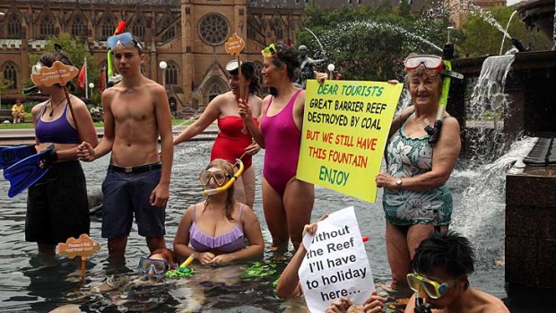 Protesters snorkel in a fountain in Sydney's Hyde Park to protest the federal government's response to UNESCO's concerns about the Great Barrier Reef.