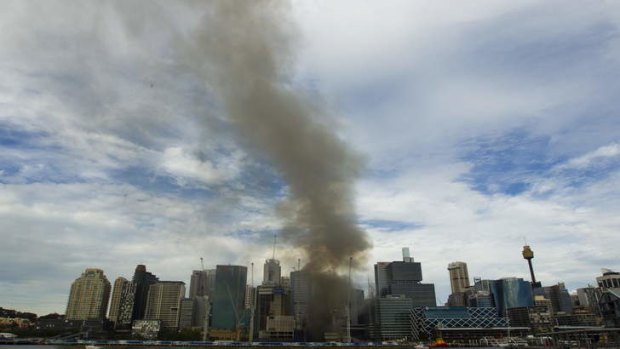A smoke plume rises from the site.