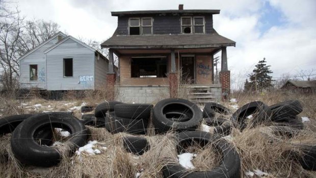 Ilegally dumped tires sit in front of a vacant, blighted home in a once thriving neighborhood on the east side of Detroit, Michigan.