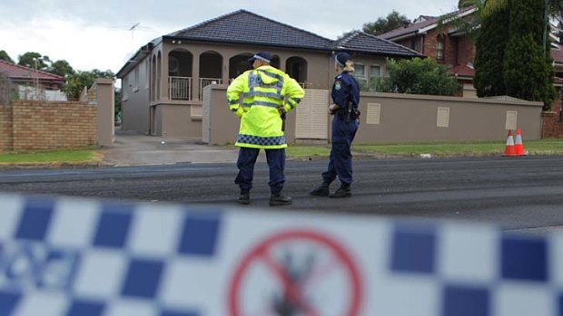 Spike in drive-bys ... police stand guard after several shots were fired at a house on Harris Street in Merrylands today.