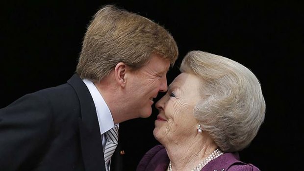 All change: King Willem-Alexander kisses his mother Princess Beatrix.