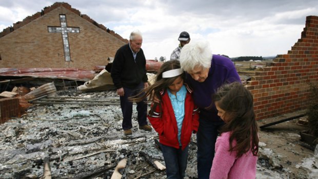 Words of comfort...Bessy McMahon speaks to Chloe and Chrystal Libreri at the remains of St Mary's Church in Kinglake. The fire consumed houses that had deluge sprinkler systems.