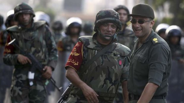 Army soldiers react as they take their positions in front of protesters who are against Egyptian President Mohammed Mursi, near the Republican Guard headquarters in Cairo.