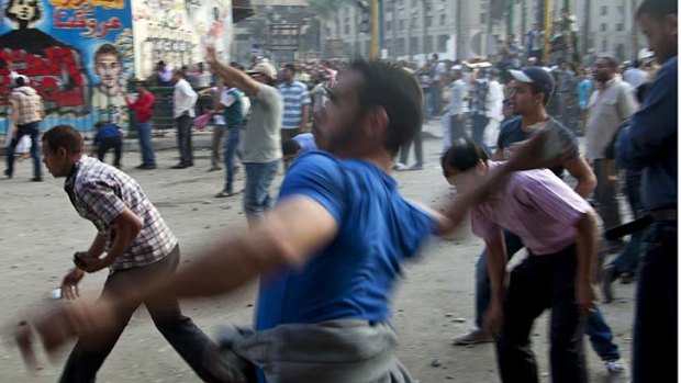 Throwing stones ... protesters in Cairo's Tahrir Square.