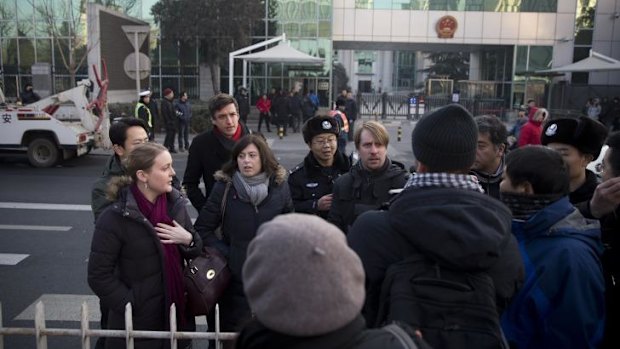 Outside the court: Chinese policemen try to block foreign diplomats talking to journalists.