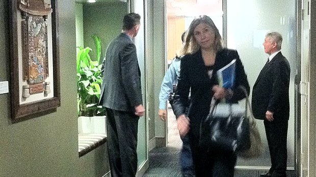 Nicole Johnston leaves council chambers with a police escort.