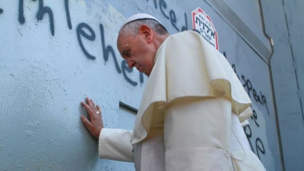 Pope Francis prays at Israel's separation barrier after he made an unscheduled stop at the security wall.