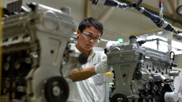 A worker assembles an engine at the General Motors plant in Wuhan, central China.
