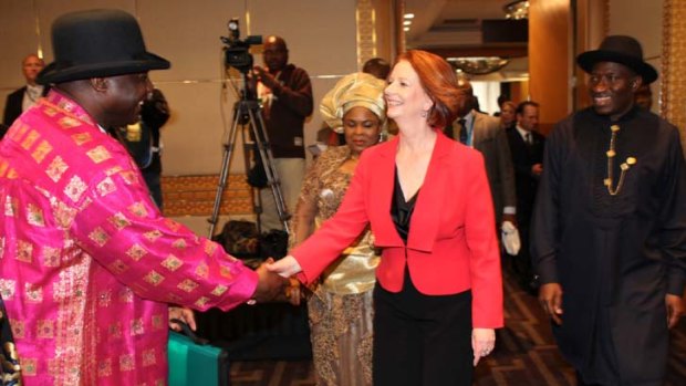 Julia Gillard greets Nigerian-Australian Emannuel Hart (in pink) and companion, as Nigerian President Goodluck Jonathan, and his wife, Patience, (in gold) look on.