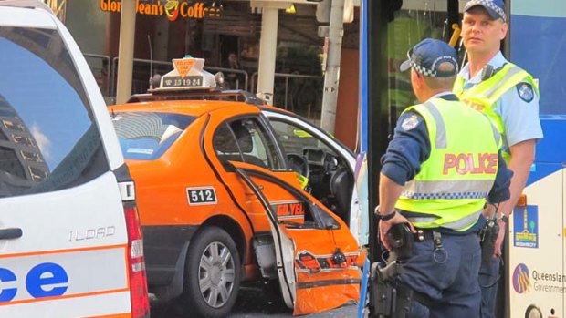 A door hangs from a cab after a collision with a bus on Adelaide Street.