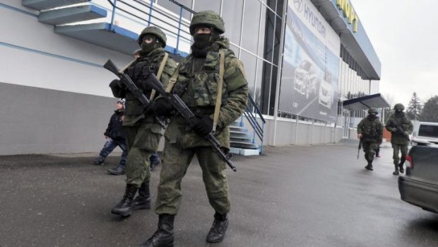 Unidentified armed men patrol outside of the Simferopol airport. Ukraine's interim government has accused Russia of staging an "armed invasion" of Crimea.