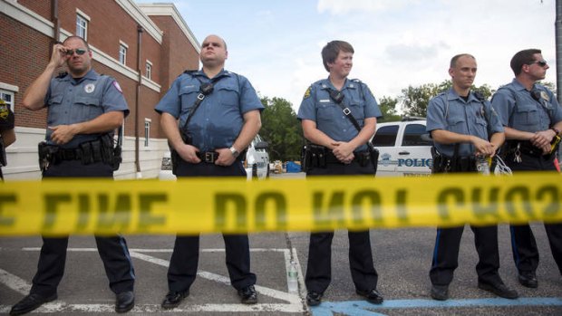 Police stand guard during a rally for Michael Brown outside the Ferguson Police Department on August 30.