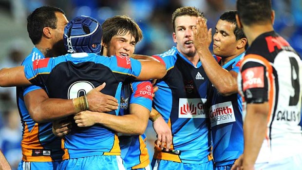 Titans players celebrate after a try on their way towards a comeback victory over Wests Tigers.