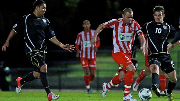 Right, said Fred: Heart captain Fred gets through a crowded Adelaide defence last night.