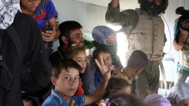 Iraqi Shiite Turkmens, mostly women and children, evacuate from the town of Amerli on board an Iraqi Army helicopter.