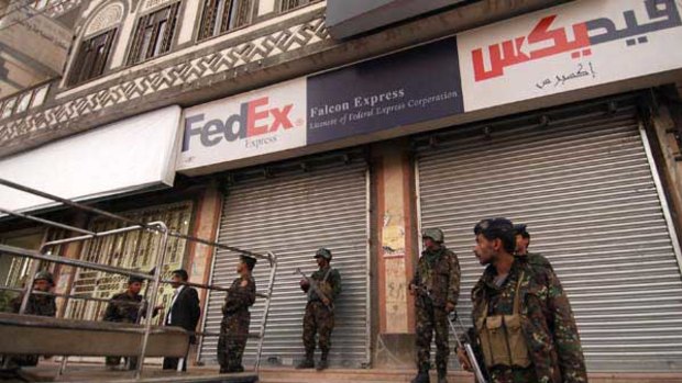 Yemeni security are seen outside a branch of the package delivery firm FedEx in Sanaa.