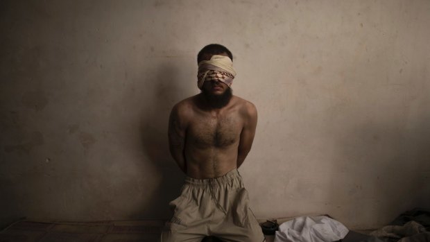 A suspected Islamic State fighter sits in a basement as Iraqi forces continue their advance in Mosul.