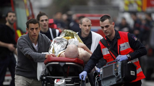 An injured person is evacuated outside the French satirical newspaper Charlie Hebdo's office in Paris.