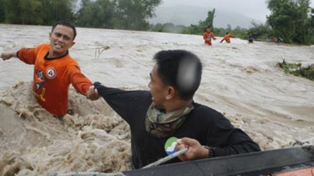Helping hand...rescuers battle floodwaters in the northern Philippines.