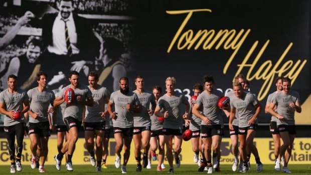 Players train in front of a billboard honouring the late Tom Hafey at punt Road.