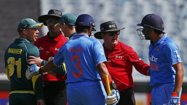 Problems of their own: David Warner argues with Rohit Sharma.