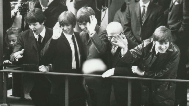 The Beatles on the Melbourne Town Hall balcony waving to adoring fans on Swanston Street. The Lord Mayor's daughter, Vikki Peters, is tucked next to Paul McCartney, far left.