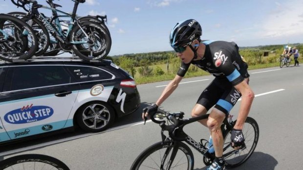 Chris Froome dangles his injured left wrist as the cuts and grazes cover the left-side of his body after crashing during the fourth stage of the Tour