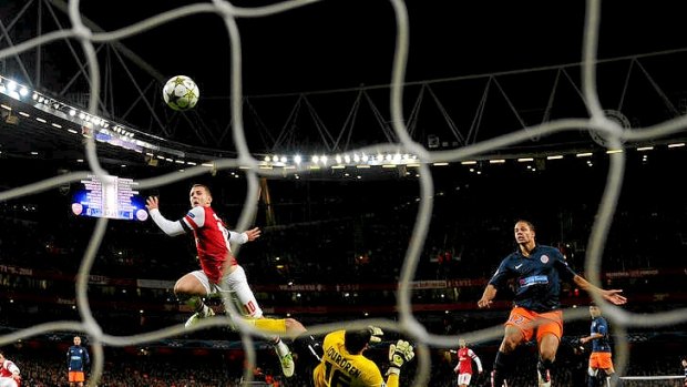 Arsenal'smidfielder Jack Wilshere scores his team's first goal to send the London club through to the next round.