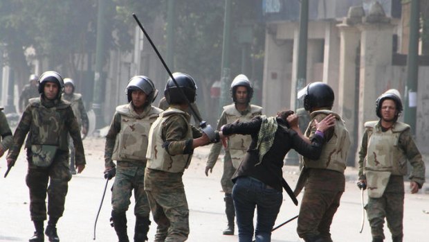 Egyptian army soldiers arrest a female protester during clashes with military police.