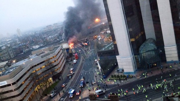 Smoke pours from the burning debris of the crashed helicopter in central London.