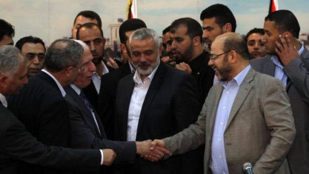 Palestinian Fatah delegation chief Azzam al-Ahmed, left, shakes hands with Hamas deputy leader Musa Abu Marzuk after the signing of a reconciliation agreement.