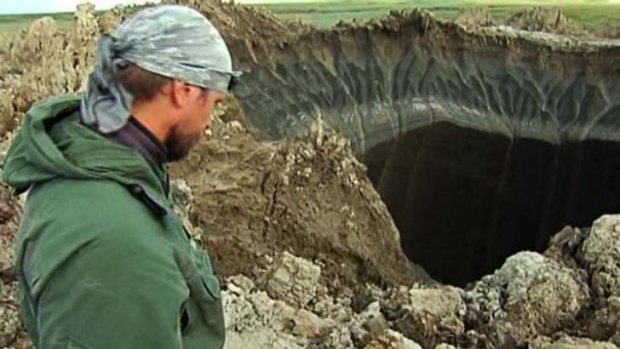 Andrei Plekhanov, a researcher at the Scientific Research Center of the Arctic, stands at the entrance to the crater.