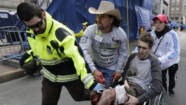 An injured man is helped through the streets of Boston after the bombings.