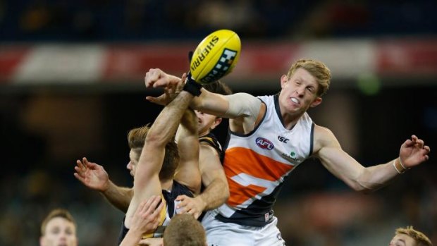 On the way up: Giants forward Sam Frost punches the ball against the Tigers.