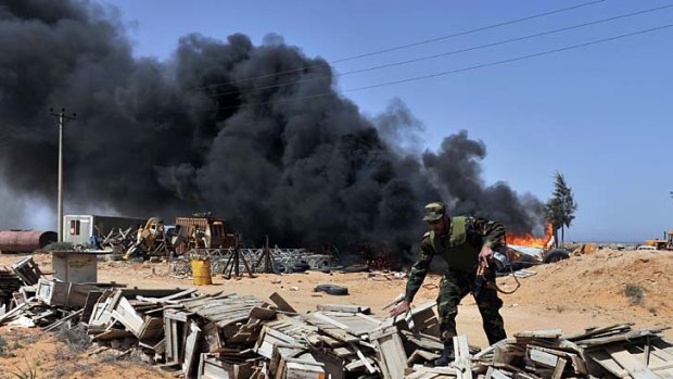 Libyan rebels burn an electricity equipment storage facility in Harawa.