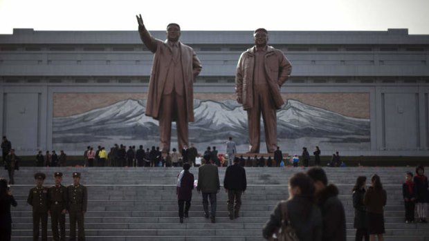 Paying respects: North Koreans visit statues of the late North Korean leaders Kim Il-sung, left, and Kim Jong-il to celebrate the 101st birthday of Kim Il-sung in Pyongyang on Monday.