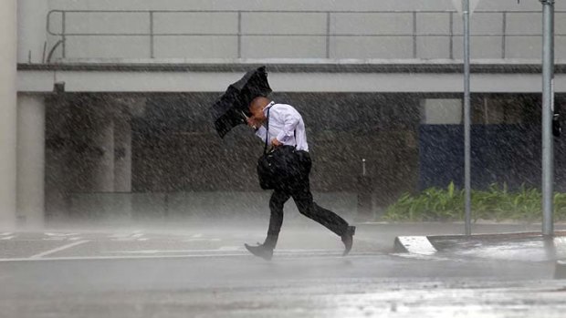 One Melbournian man catches a soaking during a sudden downpour yesterday.