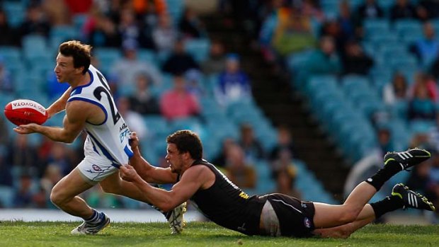 North Melbourne star Brent Harvey is tackled by Port Adelaide's Travis Boak.