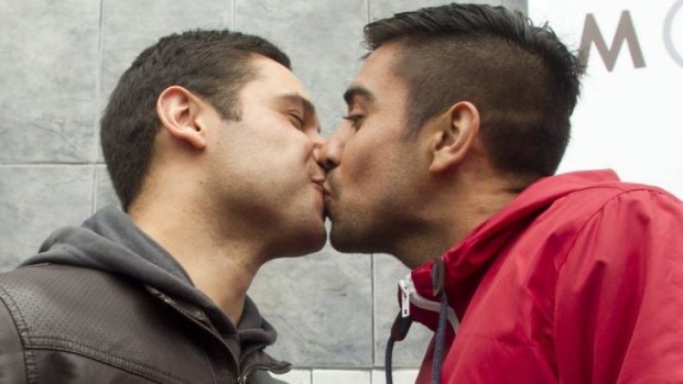 Mauricio Ruiz (left) kisses his partner Jorge Velasquez at a press conference in Santiago.